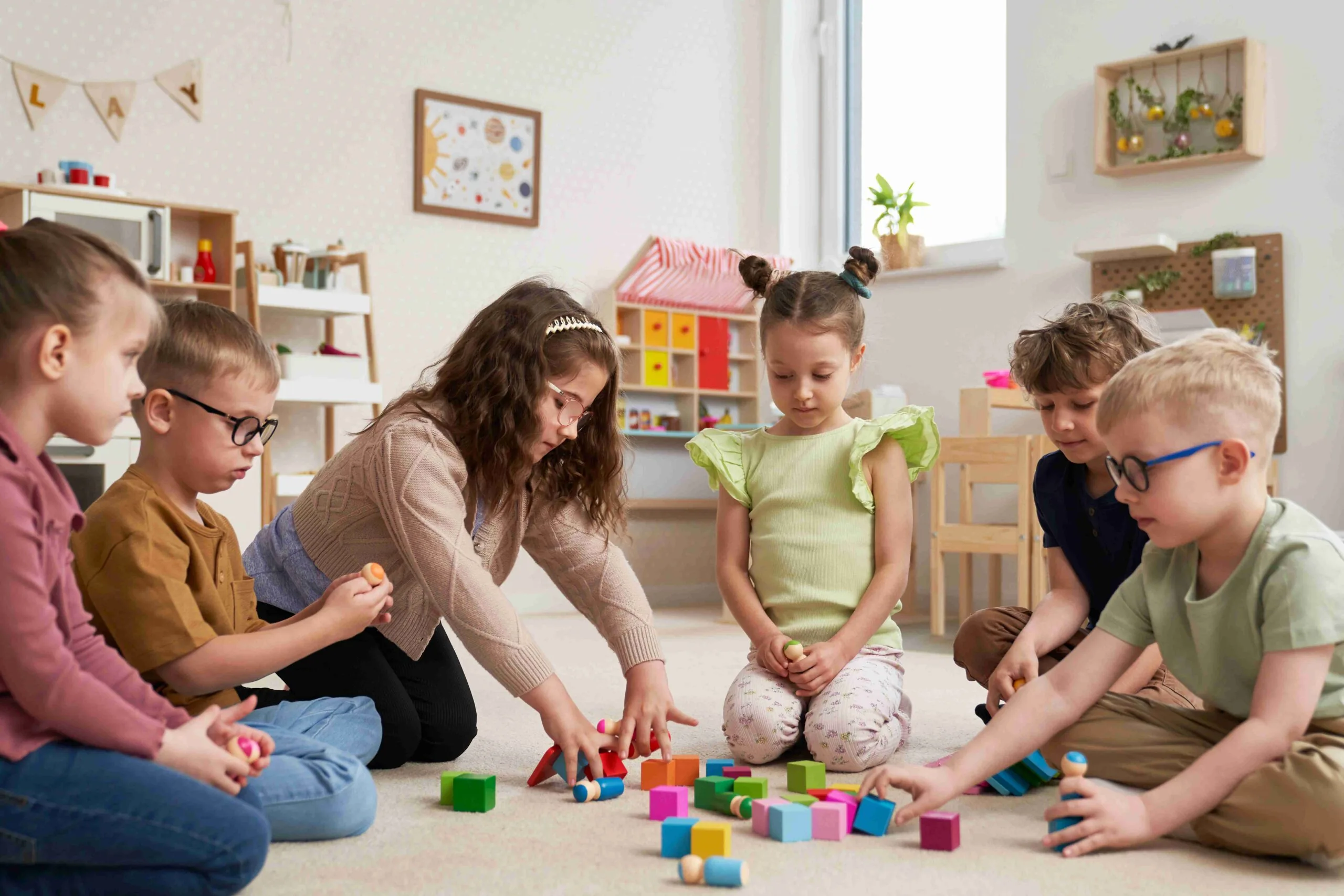 Anasınıfında montessori bloklarıyla duyu egzersizi yapan çocuklar
